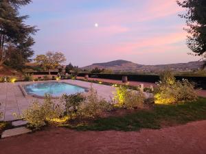 a swimming pool with lights in a yard at Château des Vierres in Lantignié-en-Beaujolais