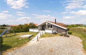 a small house with a playground and a slide at Holiday Home Dortheasvej Hvide Sande Vi in Bjerregård