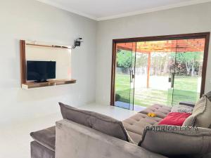 Una sala de estar con un sofá y un televisor. en Chácara próximo à São Lourenço, en Dom Viçoso