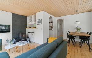 a living room with a blue couch and a table at Nice Home In Aakirkeby With Wifi in Vester Sømarken