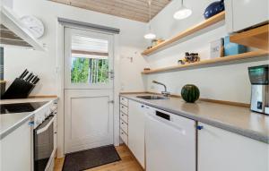 a kitchen with white cabinets and a window at Nice Home In Aakirkeby With Wifi in Vester Sømarken