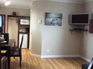 a living room with a television on a wall at Miami Motel in Trois-Rivières