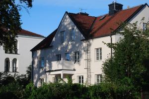 une maison blanche avec un toit rouge dans l'établissement Hotell Östermalm, à Motala