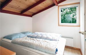 a bed in a room with a window at Holiday Home Hemmet 25 in Falen +3 photos