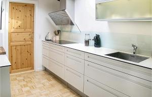 a kitchen with white cabinets and a sink at Holiday Home Hemmet 25 in Falen