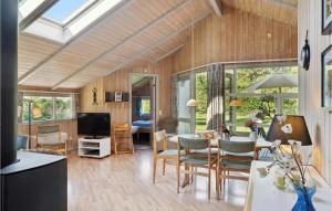 a living room with wood paneling and a dining room at Holiday Home Birkely Ii in Nysted