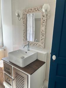 a bathroom with a white sink and a mirror at Maison Cosy Bord de Mer in Dives-sur-Mer