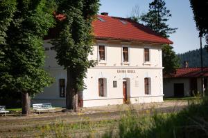 an old white building with a red roof at Apartamenty Stacja Kasina in Kasina Wielka