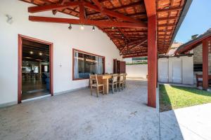 an outdoor patio with a table and chairs at Casa Beira mar, com Jacuzzi no centro de Bombinhas in Bombinhas +37 photos
