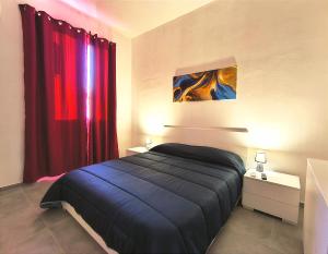 锡拉库扎Casa Euripide的一间卧室配有床和红色窗帘