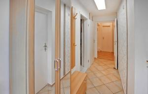 Ferienwohnung Waren Müritz في Warenshof: ممر به جدران بيضاء وباب وأرضية من البلاط +5 صور