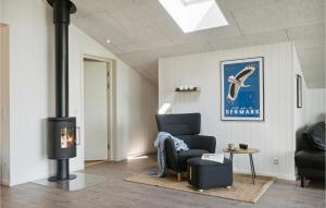 a living room with a chair and a fireplace at Cozy Home In Blåvand With Kitchen in Blåvand