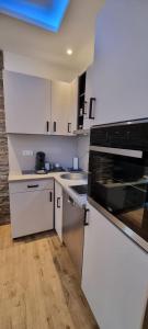 a kitchen with white cabinets and a stove top oven at Apartman Magic house in Kruševac