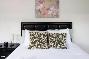 un dormitorio con una cama con sábanas y almohadas blancas en Plumeria Housing, en Fort Lauderdale 41 fotos más