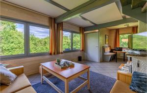 un soggiorno con un tavolo e alcune finestre di Ferienhaus 105 In Kirchheim a Kemmerode