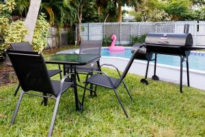 una parrilla y dos sillas y una mesa en un patio en Plumeria Housing, en Fort Lauderdale