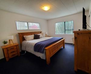 ワイヒ・ビーチにあるQuiet 2 Bedroom Retreat near the Beachの大きなベッドと2つの窓がある寝室