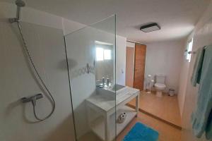 ein Badezimmer mit Glasdusche und Toilette in der Unterkunft Yellow House in Jardim do Mar + 14 Fotos