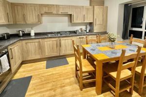 a kitchen with a wooden table with chairs and a dining room at Unique Stays Modern Evergreen House in Ashford! in Ashford +15 photos