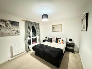 a bedroom with a large bed and a window at Unique Stays Modern Evergreen House in Ashford! in Ashford