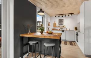 a kitchen with a wooden counter and stools at Awesome Home In Slagelse With Kitchen in Slagelse