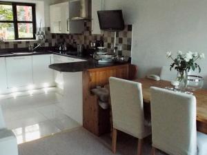 a kitchen with a wooden table with chairs and a counter at Four Seasons in Staveley +16 photos