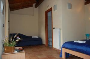 a bedroom with a blue bed and a couch at Family Resort Cala di Luna in Marina di Camerota
