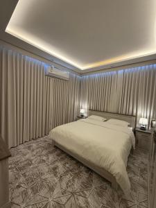 une chambre avec un grand lit et deux tables de nuit dans l'établissement شقه مفروشه 2 قريبه من المطار, à Tabuk
