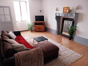 a living room with a couch and a fireplace at L'Escapade Jurassienne in Beaufort