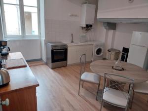 a kitchen with a table and chairs in a kitchen at L'Escapade Jurassienne in Beaufort