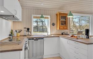 a kitchen with white cabinets and white appliances at Stunning Home In Sjællands Odde in Yderby