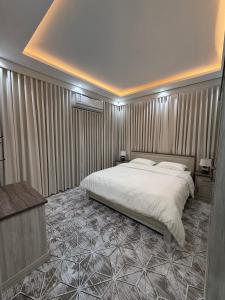 - une chambre avec un grand lit blanc et des rideaux dans l'établissement شقه مفروشه 2 قريبه من المطار, à Tabuk 2 autres photos