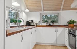 a kitchen with white cabinets and a window at 4 Bedroom Beautiful Home In Melby in Melby