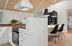 a kitchen with white cabinets and black chairs at 4 Bedroom Beautiful Home In Melby in Melby