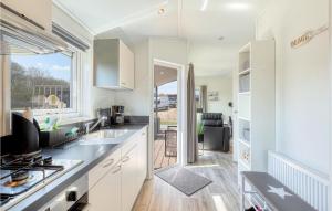 a kitchen with white cabinets and a view of a patio at 2 Bedroom Amazing Home In Süsel in Süsel