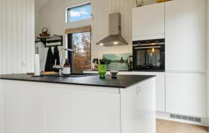 a kitchen with white cabinets and a black counter top at Awesome Home In Dannemare With Kitchen in Dannemare