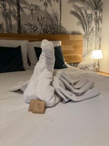a pile of white towels sitting on a bed at Les Pénates de Loire in Ancenis