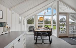 a kitchen with a table with chairs and a large window at Amazing Home In Tarm With Wifi in Tarm