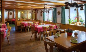 Gasthaus Pension Zum Löwen في غرافنهاوسن: مطعم بطاولات وكراسي وطاولات وردية