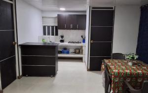 a kitchen with black cabinets and a table in a room at Urantia Casa de la Montaña in Sutatausa +5 photos