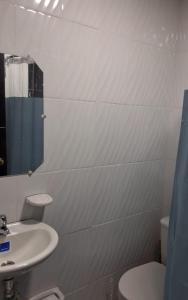 a white bathroom with a sink and a toilet at Urantia Casa de la Montaña in Sutatausa