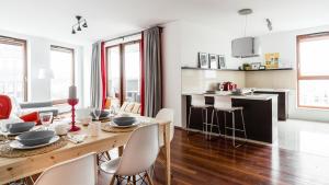 eine Küche und ein Wohnzimmer mit einem Tisch und Stühlen in der Unterkunft Glob Apartament Sea Towers Gdynia in Gdynia