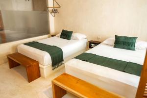 Ένα ή περισσότερα κρεβάτια σε δωμάτιο στο Koos Tulum Hotel