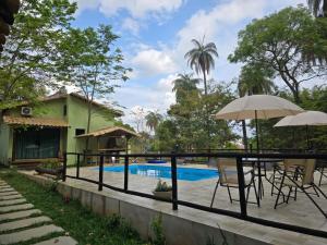 a patio with tables and umbrellas next to a swimming pool at Pousada Cigarras da Serra in Serra do Cipo