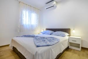 1 dormitorio con 1 cama blanca grande con almohadas azules en Imperium Apartments, en Dubrovnik