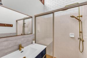 a bathroom with a shower and a white sink at Unit 5 13 Short Street, Merimbula in Merimbula +6 photos