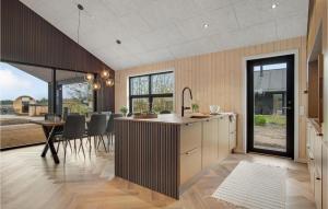an open kitchen and dining room with a dining table at Cozy Home In Tarm With Sauna in Tarm