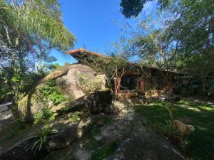 a house with a large rock in front of it at Casa Atelie Bangue in Ilhabela