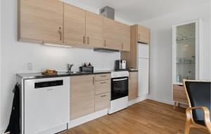 a kitchen with white appliances and wooden cabinets at Awesome Apartment In Allinge With Wifi in Allinge