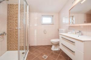 ein Badezimmer mit Dusche, Toilette und Waschbecken in der Unterkunft Apartments Svarog in Biograd na Moru